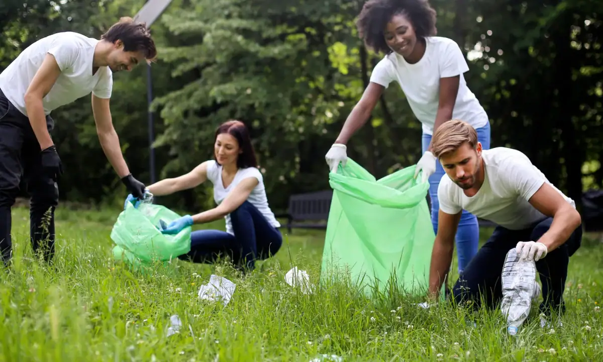 Neighbors picking up debris together in a grassy field