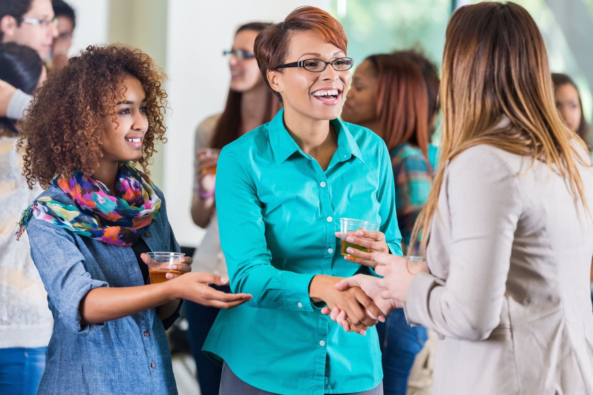 Guests introducing themselves with a handshake at a gathering.